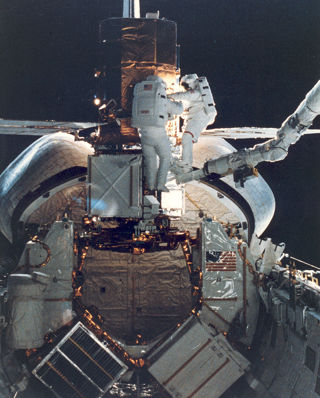 Two astronauts performing repairs on a Space Shuttle.